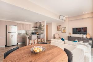 una cucina e un soggiorno con tavolo in legno in una camera di Apartment at Regatta Living II - 406 fully-equipped a Los Prados