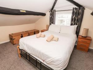 a bedroom with a large bed with two towels on it at Scotch Hall Cottage in Llangollen