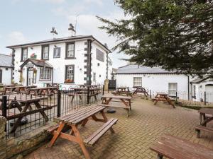 a group of picnic tables in front of a building at Scotch Hall Cottage in Llangollen