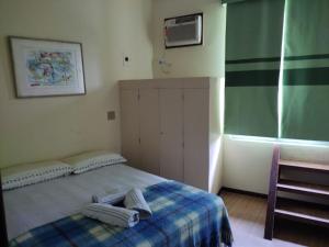 マンガラチバにあるBelamar Hotelのベッドルーム1室(ベッド1台、タオル2枚付)