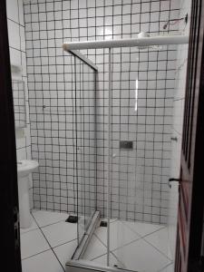 a shower in a bathroom with white tile at Belamar Hotel in Mangaratiba
