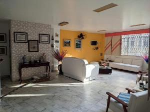 マンガラチバにあるBelamar Hotelの白い家具と黄色の壁が特徴のリビングルーム