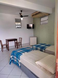 マンガラチバにあるBelamar Hotelのベッド2台、テーブル、椅子が備わる客室です。