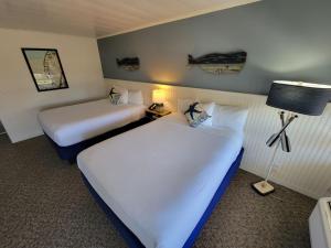 فندق سيركل فيرفيلد في فيرفيلد: سريرين في غرفة الفندق ذات شراشف بيضاء