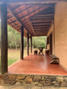 a porch with a wooden deck with a stone wall at Chico Bertolino / Reserva Alto da Colina in Conceição da Ibitipoca