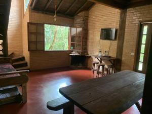 a large room with a wooden table and a kitchen at Chico Bertolino / Reserva Alto da Colina in Conceição da Ibitipoca