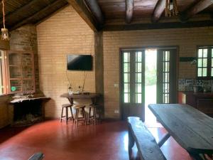 a living room with a wooden table and a tv at Chico Bertolino / Reserva Alto da Colina in Conceição da Ibitipoca +15 photos