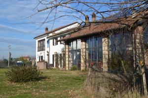 una casa antigua con ventanas en un campo en Cascina Trapella, en Terruggia