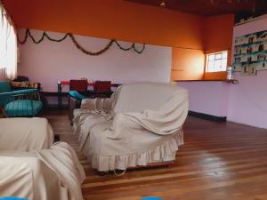um quarto com uma fila de camas com lençóis brancos em Hospedaje Chimborazo em Chimborazo