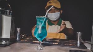 a man wearing a mask and a blue drink on a table at EL MANÁ in Huarmey