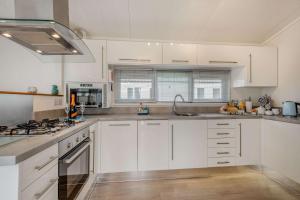 a kitchen with white cabinets and stainless steel appliances at Bay Hollow in Poole