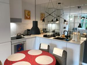 uma cozinha com uma mesa vermelha e branca numa cozinha em Nice Place em Gdansk