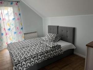 sypialnia z łóżkiem z czarno-białą kołdrą w obiekcie Domek wypoczynkowy MK w mieście Puck