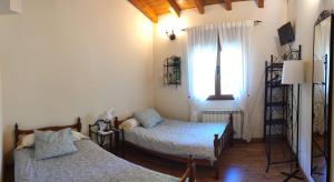 Habitación pequeña con 2 camas y ventana en Casa Rural Refugio del Cueto***, en Villamanín