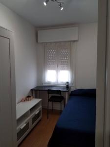 sypialnia z łóżkiem, biurkiem i oknem w obiekcie Hostal El Caracol w mieście Valdemoro