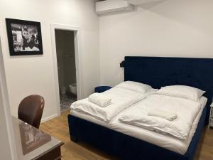 łóżko z niebieskim zagłówkiem w pokoju w obiekcie Shone apartment old town w Bratysławie