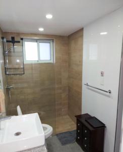 y baño con aseo, lavabo y ducha. en Ocean Palms - 1Bed 1Bth King Suite Condo en Cabarete