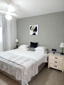 Un dormitorio con una gran cama blanca y una mesa en Ocean Palms - 1Bed 1Bth King Suite Condo en Cabarete