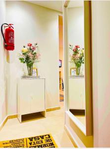 a room with two vases of flowers in a mirror at MADRID CENTRO in Madrid