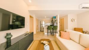 a living room with a white couch and a table at Fully Serviced Apartment at Regatta Living II - 703 in Santo Domingo