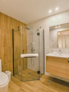 a bathroom with a shower and a toilet and a sink at Fully Serviced Apartment at Regatta Living II - 703 in Santo Domingo