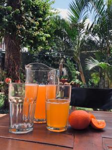 three glasses of orange juice on a wooden table at Edificio Itasu - 4to - alquileres temporales in Posadas