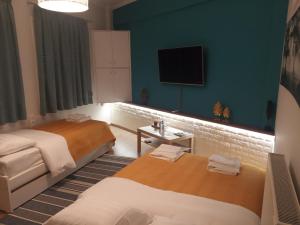 um quarto de hotel com duas camas e uma televisão de ecrã plano em Korte Apartment 1 em Arta