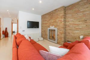 sala de estar con sofá rojo y pared de ladrillo en Fragata Sitges Rentals, en Sitges