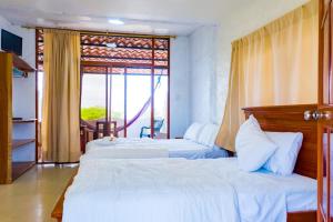 Habitación de hotel con 2 camas y ventana en Royal Galápagos Inn, en Puerto Baquerizo Moreno