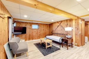 a bedroom with a bed and a tv and a chair at Modern Log Chalet - Lower Unit in Montgomery