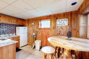 a kitchen with wooden walls and a wooden table at Modern Log Chalet - Lower Unit in Montgomery