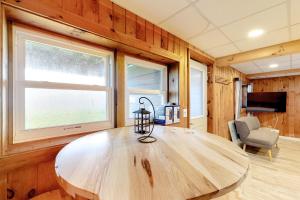 a large wooden table in a room with windows at Modern Log Chalet - Lower Unit in Montgomery +3 photos