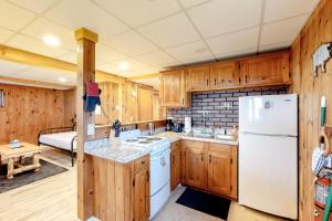 a kitchen with wooden cabinets and a white refrigerator at Modern Log Chalet - Lower Unit in Montgomery