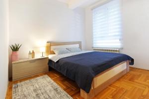 una camera da letto con un letto grande e una finestra di Lion Apartment - Belgrade a Belgrado