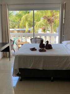 a bedroom with a bed with two pairs of shoes on it at Canoa Suites & Apartments in Canoa Quebrada