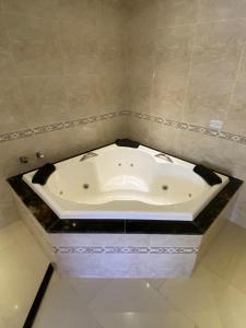 a white bath tub in a bathroom with a counter at Canoa Suites & Apartments in Canoa Quebrada