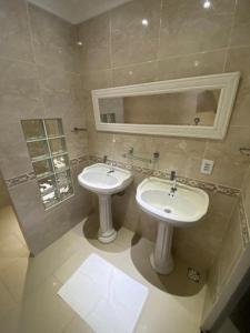 a bathroom with two sinks and a mirror at Canoa Suites & Apartments in Canoa Quebrada
