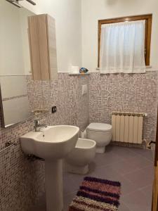 y baño con lavabo, aseo y espejo. en Casa Sossi, en Montagnano