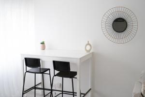 um balcão branco com duas cadeiras e um espelho em Charmant appartement 2 pièces em Valence