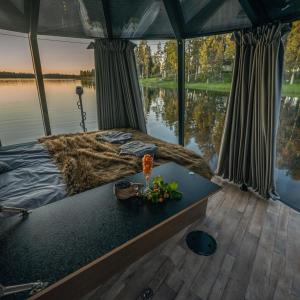 Bett in einem Boot mit Blick auf das Wasser in der Unterkunft Aurora Hut Igloo by Invisible Forest Lodge in Rovaniemi