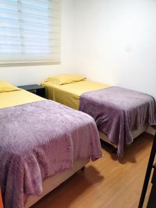 two beds sitting next to each other in a room at Apto NOVO região Shopping Pantanal/Centro Político in Cuiabá