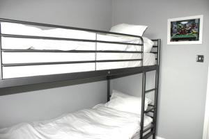 a bunk bed with white pillows on a bunk bed at Lovely, cosy 3 bedroom apartment in Teddington