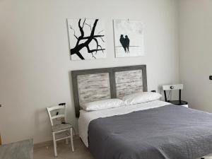 1 dormitorio con 1 cama y 2 cuadros en la pared en Casa Sossi, en Montagnano