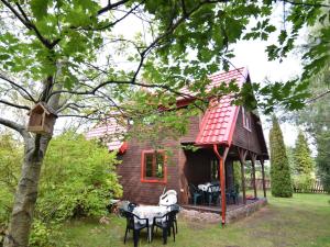 uma pequena casa com mesas e cadeiras em frente em holiday home, Zuromino em Żuromino