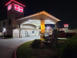 a mobil gas station with a sign at night at Platinum Inn Katy in Katy