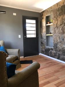 uma sala de estar com duas cadeiras e uma porta preta em La Osadia Cabañas y Suites Solo Adultos em Mina Clavero