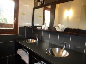 two sinks in a bathroom with two mirrors at La Cascade in Mouthier-Haute-Pierre