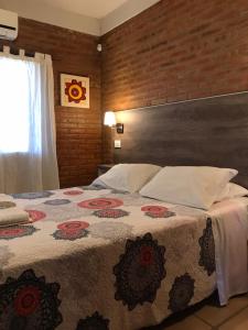 - une chambre avec un grand lit et une couverture fleurie dans l'établissement La Osadia Cabañas y Suites Solo Adultos, à Mina Clavero