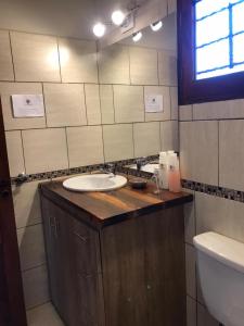 La salle de bains est pourvue d'un lavabo et de toilettes. dans l'établissement La Osadia Cabañas y Suites Solo Adultos, à Mina Clavero
