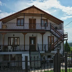 a large white house with a wooden roof at Wooden Sofita House with Unlimited View in Grevena